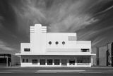 black and white photo of a white art deco building with round windows