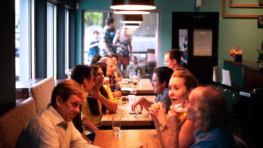 Men and women drinking at a table in a restaurant