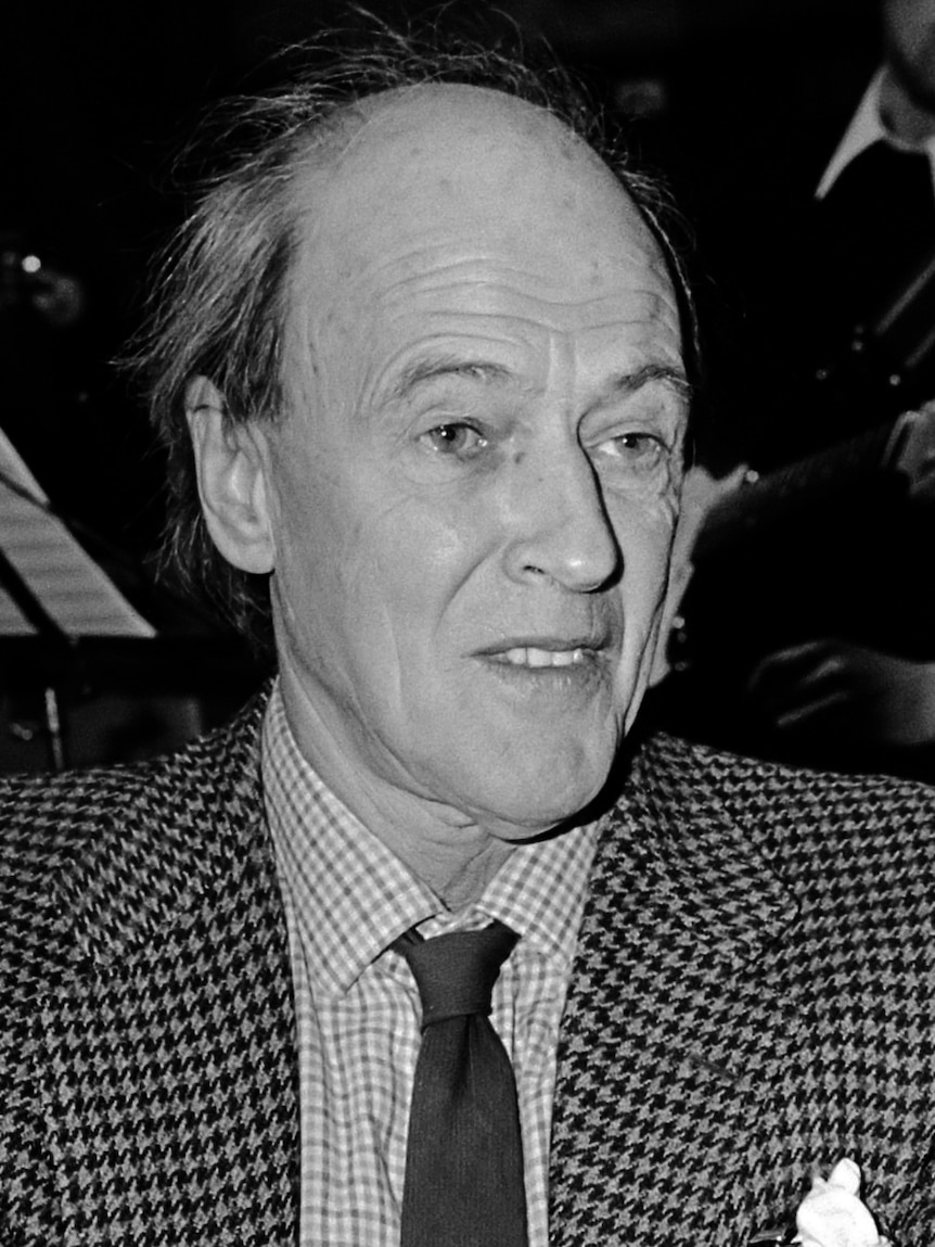 Roald Dahl wearing a dark suit and tie.
