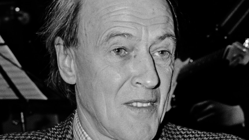 Roald Dahl wearing a dark suit and tie.