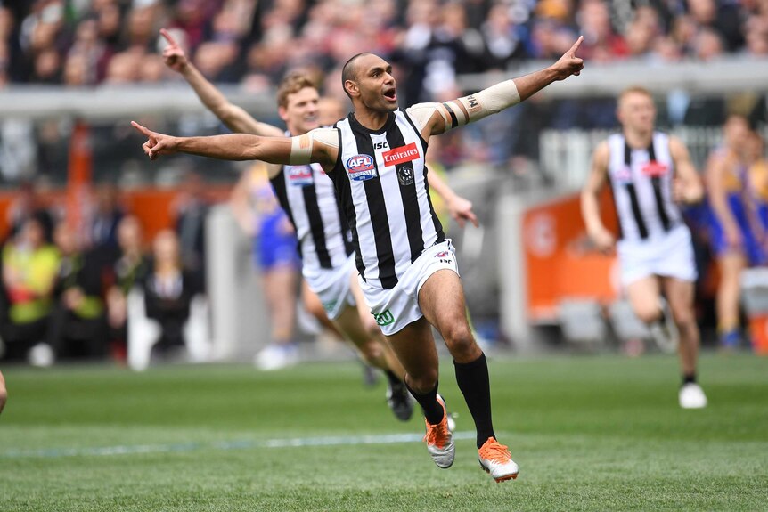 Travis Varcoe celebrates with his arms wide open after kicking the opening goal in the AFL grand final.