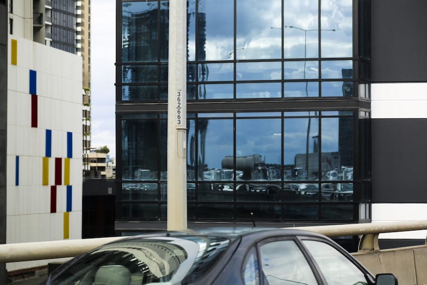 Traffic can be seen as a standstill in the reflection of a glass building