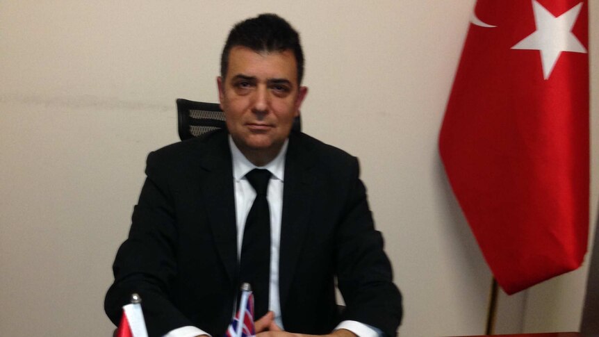 Sydney's Turkish consul general Melih Karalar sits at his desk, flanked by Turkey's flag.