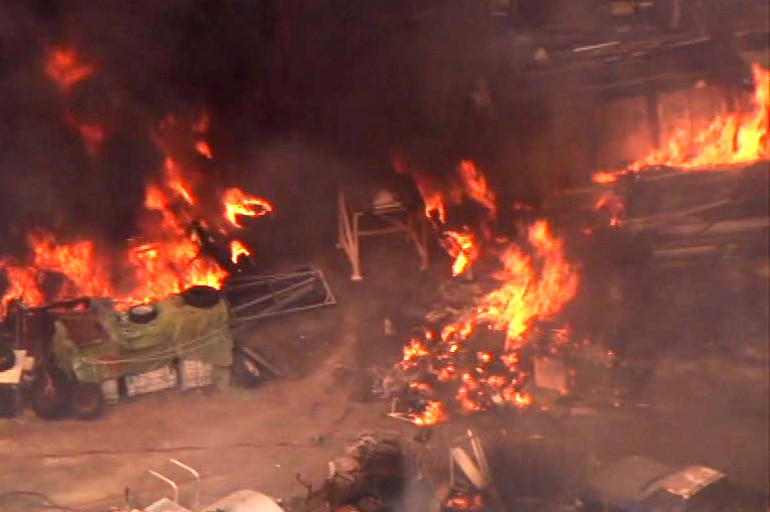 A helicopter shot of a structure on fire.