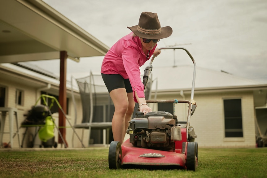 woman starting a push mower