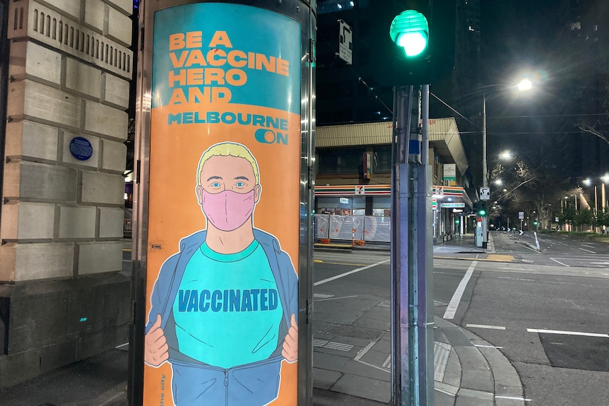 A vaccination poster with a cartoon of a 'vaccine hero', on a post on a CBD street.