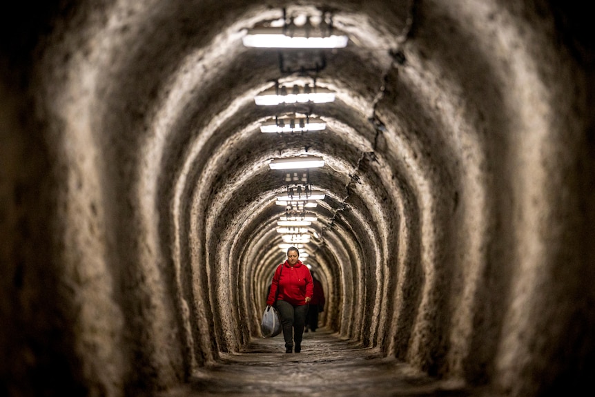 A woman walks inside an access gallery of the Salina Turda, a former salt mine turned tourist attraction.