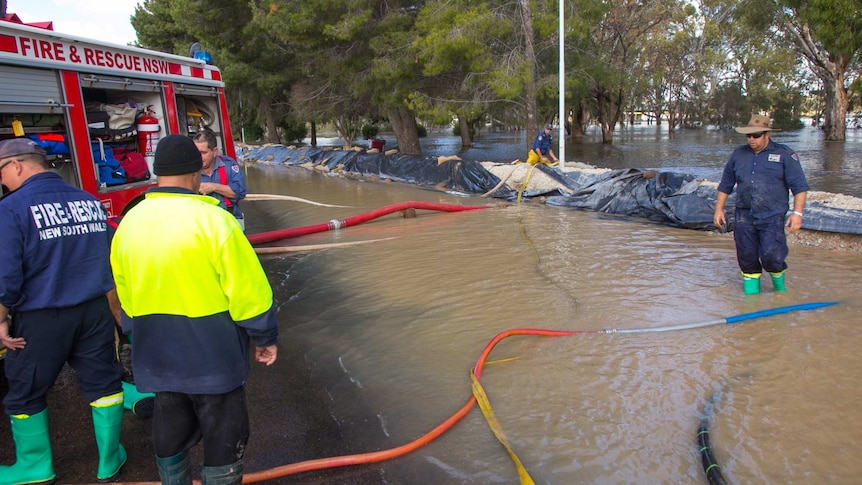 Fire and Rescue crews pump water which had seeped through a temporary levee bank holding back the rising Lachlan River.