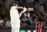 England batter Mark Wood completes his strokes as a cricket ball hits his stumps.