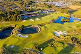 A lush golf course with houses at its edge 