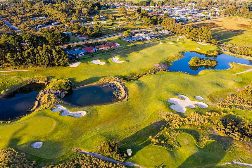 A lush golf course with houses at its edge 