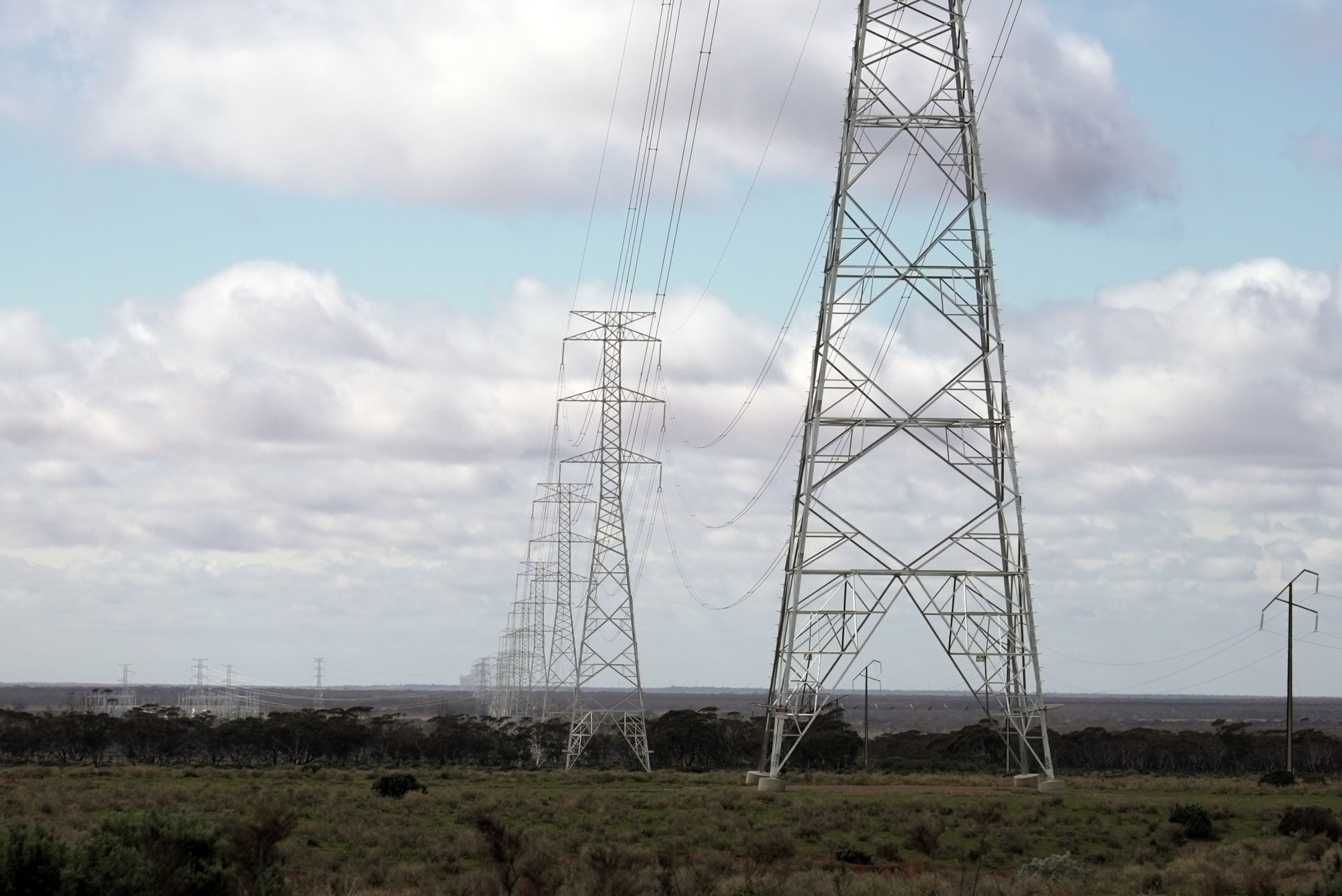 A long  line of transmission towers in a country area.