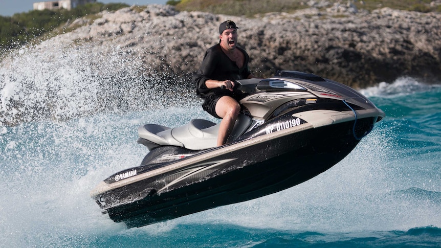 Billy McFarland rides a jetski in the Bahamas while organising the Fyre Festival.