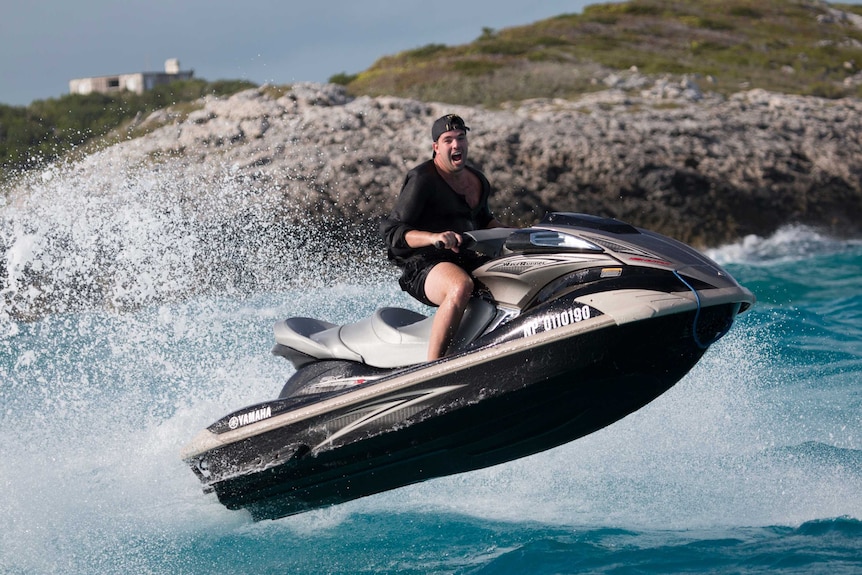 Billy McFarland rides a jetski in the Bahamas while organising the Fyre Festival.