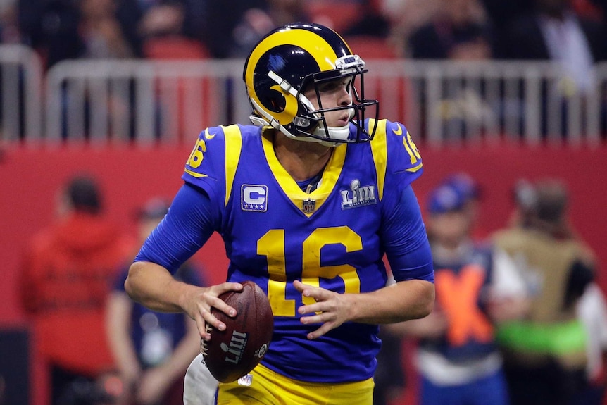 Jared Goff holds the ball in his right hand as he looks to pass for the Rams against the Patriots.
