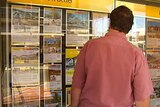 A man looks at ads in a Northern Territory real estate agency