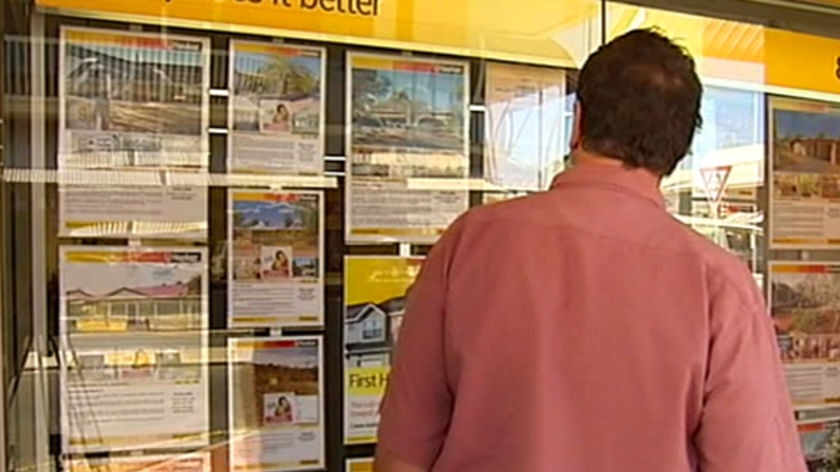 A man looks at ads in a Northern Territory real estate agency