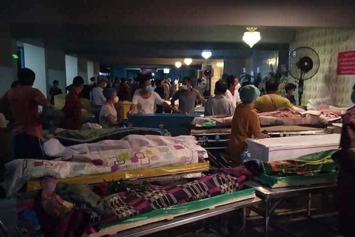 People crowd with the bodies of people who have died of COVID-19 outside one of Yangon's busiest crematoriums.