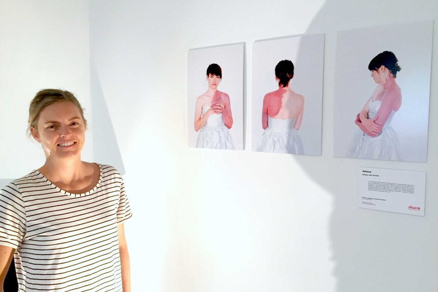 Natalie McComas stands in front of her exhibition 'In This Skin'.
