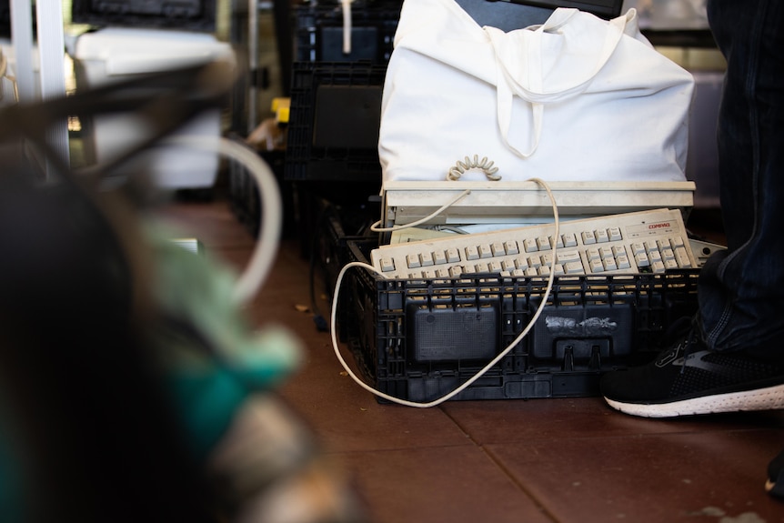 Old keyboards and other electronics in a crate.