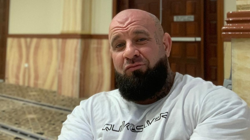 A man inside a mosque and smiling to camera