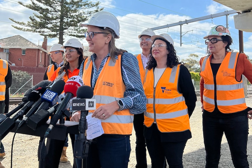 Victorian Premier Jacinta Allan addresses the media wearing a high-vis vest and hard hat.
