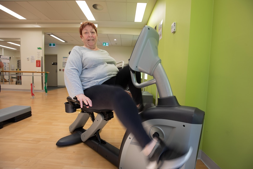 A woman on an exercise bike.