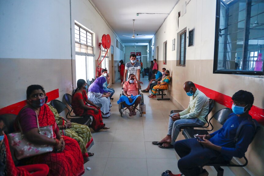 A hospital in India with many people wearing masks.