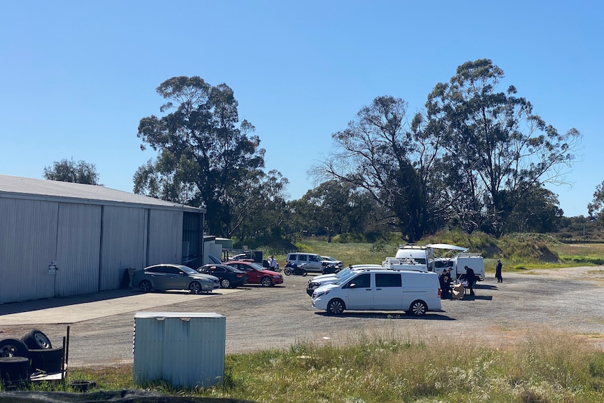 Police collecting evidence at a large warehouse on a rural property