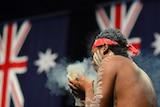 A member of the Noonuccal Dancers performs a smoking ceremony.