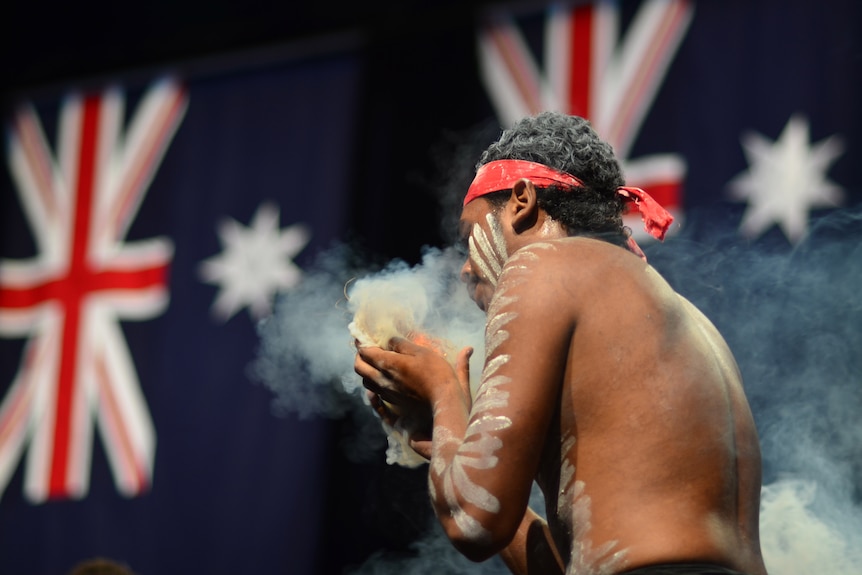 A member of the Noonuccal Dancers performs a smoking ceremony.