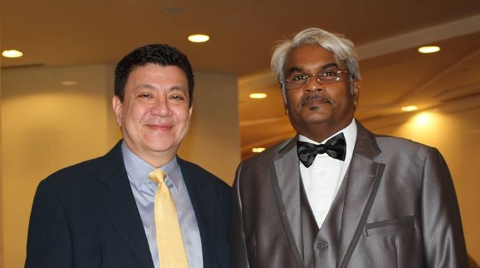 Sivakumar Ganapathy wearing a silver suit, standing next to Philip Mills who heads AsiaPR's presence in Phnom Penh