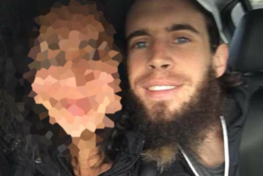 Damien Featherstone poses with another person, whose face is pixelated.