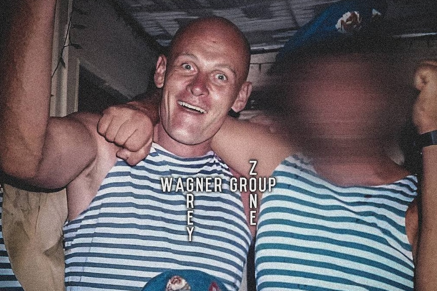 A close up of a man wearing a striped blue shirt with his arms around another man.