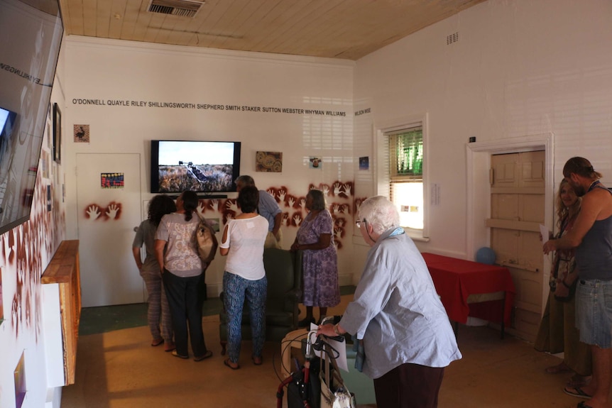Locals looking at an exhibition at Wilcannia's Queens Head Hotel gallery.