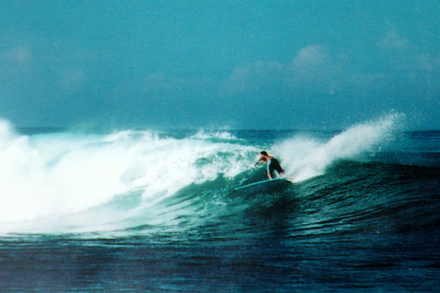 man surfing a wave out in the ocean