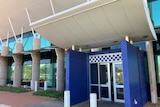 photo of the exterior of a police station with blue and white checks above doors