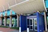 photo of the exterior of a police station with blue and white checks above doors