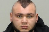 An official police photo of a man wearing a black hoodie.