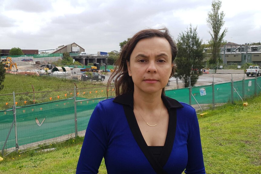 Pauline Lockie stands in front of WestConnex construction.