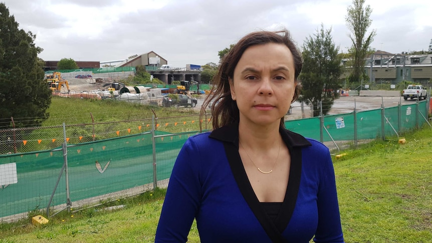 Pauline Lockie stands in front of WestConnex construction.