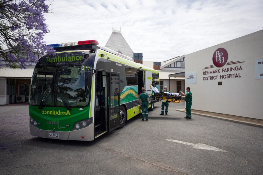 A bus painted in ambulance service colours outside a hospital