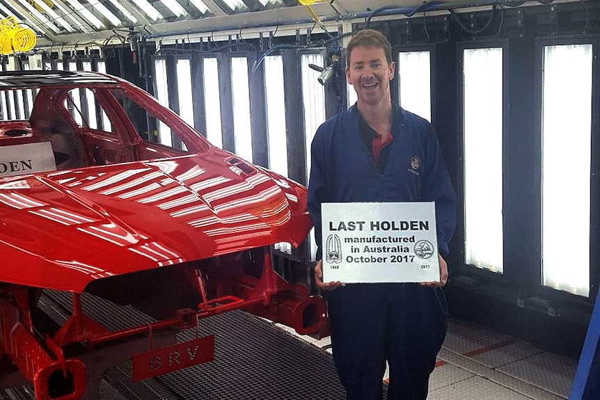 Holden worker Kane Butterfield with the last car produced at the Elizabeth plant on October 19, 2017.