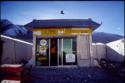 The China post office is pictured with mountains in the background and birds flying.