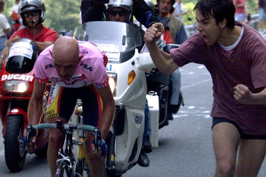 Marco Pantani rides past a fan who shouts at him