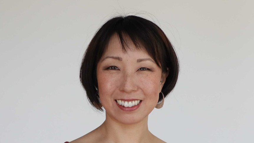 headshot of author Justine Toh, wearing a red top
