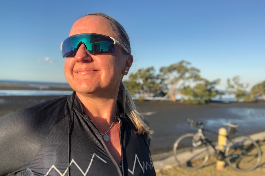 Lisa Wilkins smiles wearing cycling gear at Nudgee Beach