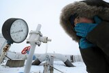 Ukraine woman looks at gas pipe manometre