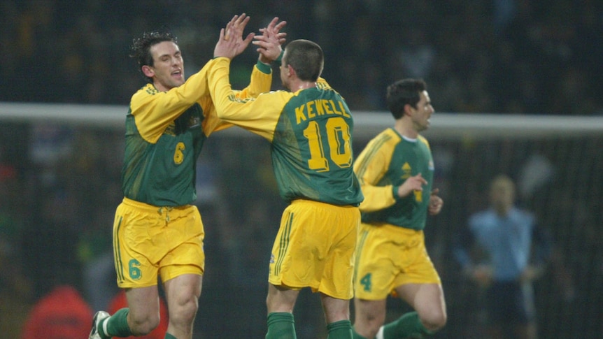 Socceroos Tony Popovic and Harry Kewell high five during a match against England.