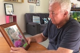 Steve Peek looks at a picture of his daughter Suli at his home.